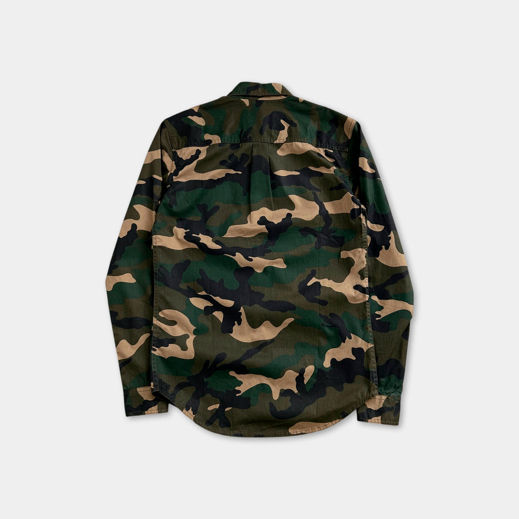 the back of a camouflage-patterned shirt against a white background.