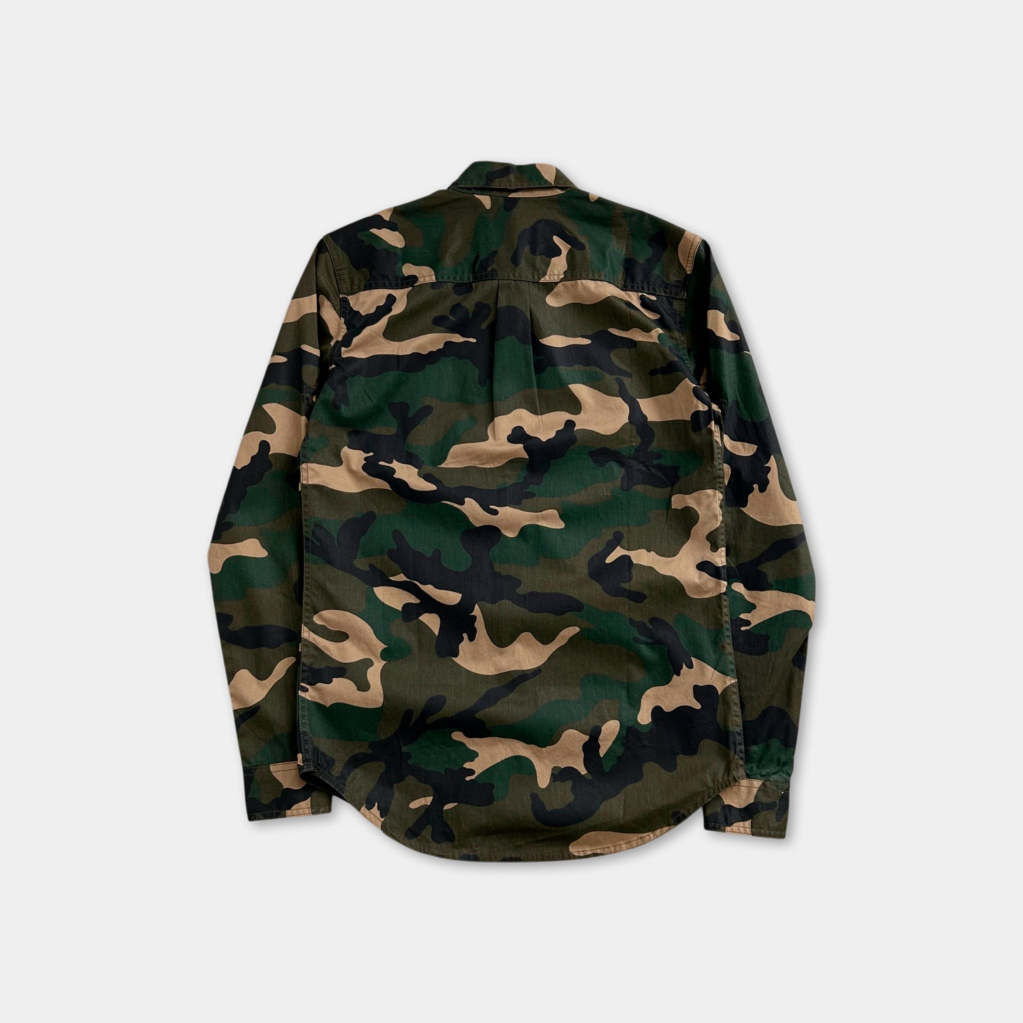the back of a camouflage-patterned shirt against a white background.