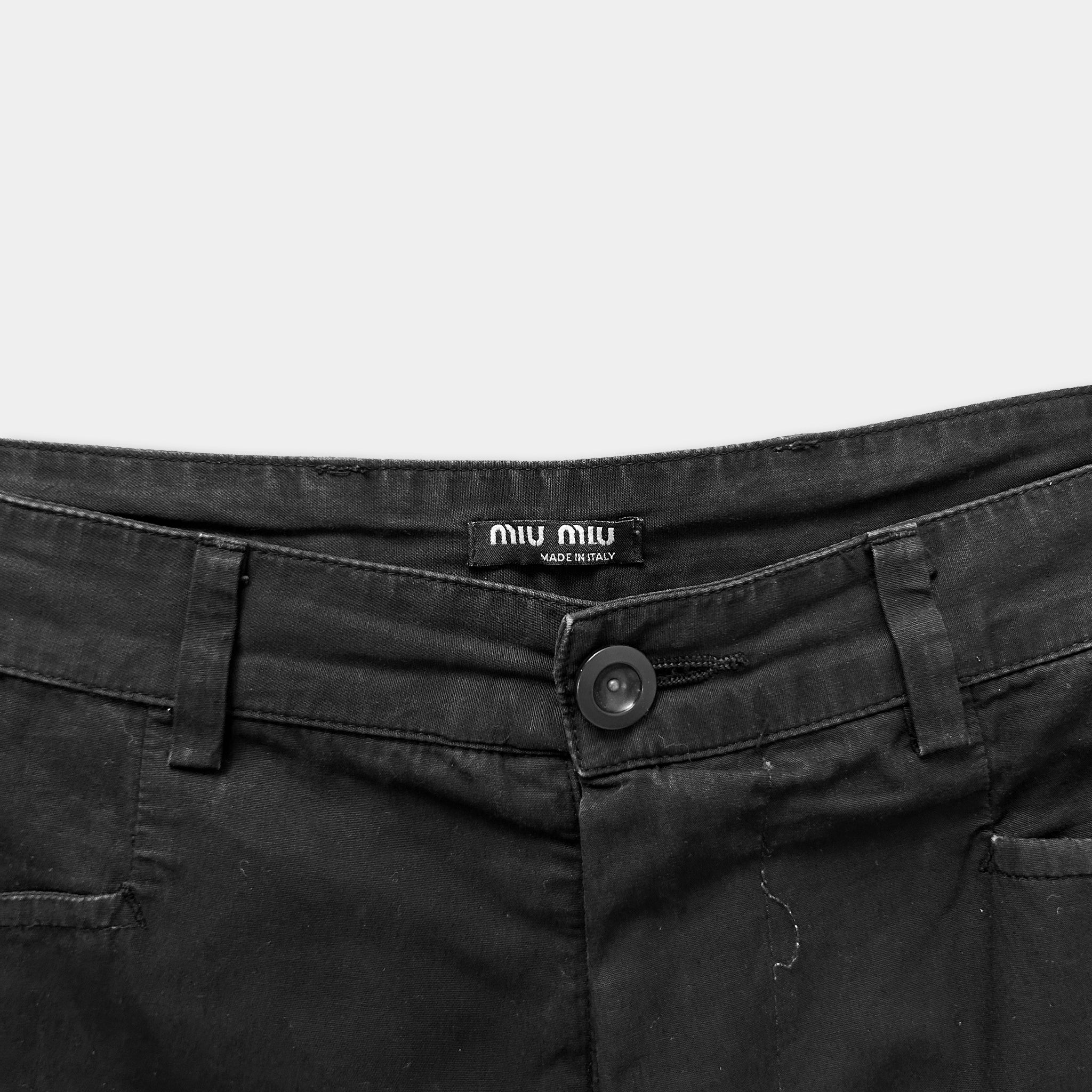 A close-up view of a pair of black pants with a label on the waistband.