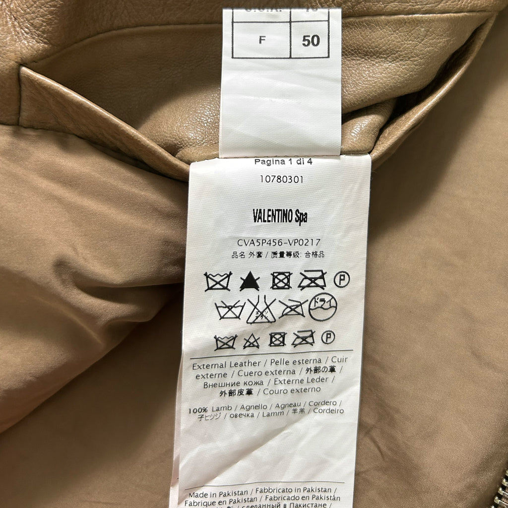 a close-up view of a piece of clothing with a label attached to it, which contains text and symbols related to the garment's care instructions.