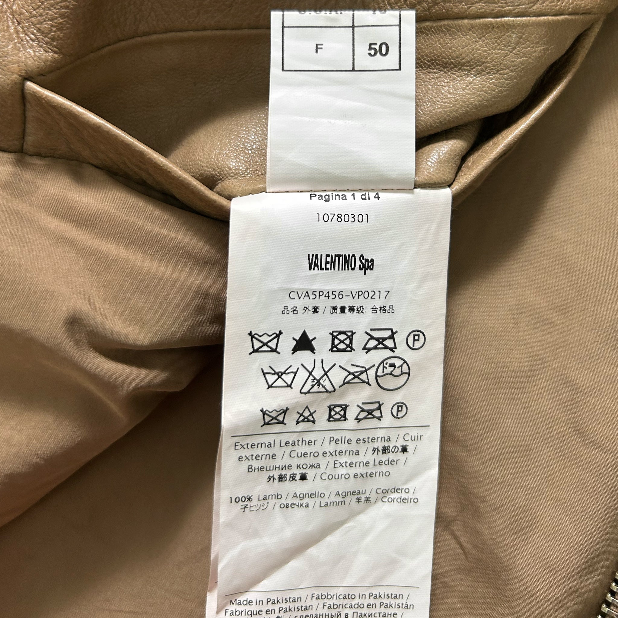 a close-up view of a piece of clothing with a label attached to it, which contains text and symbols related to the garment's care instructions.