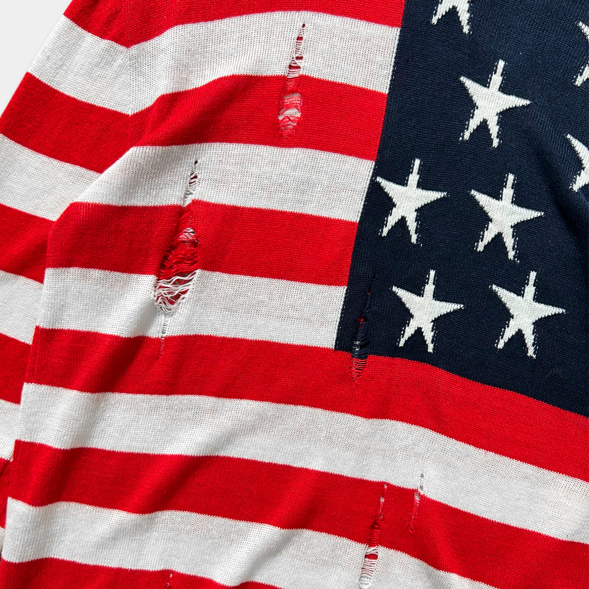 a close-up view of a fabric with a torn American flag design.