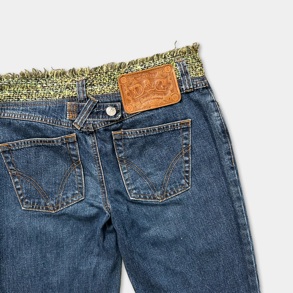 A pair of blue jeans with a brown leather patch on the back pocket.