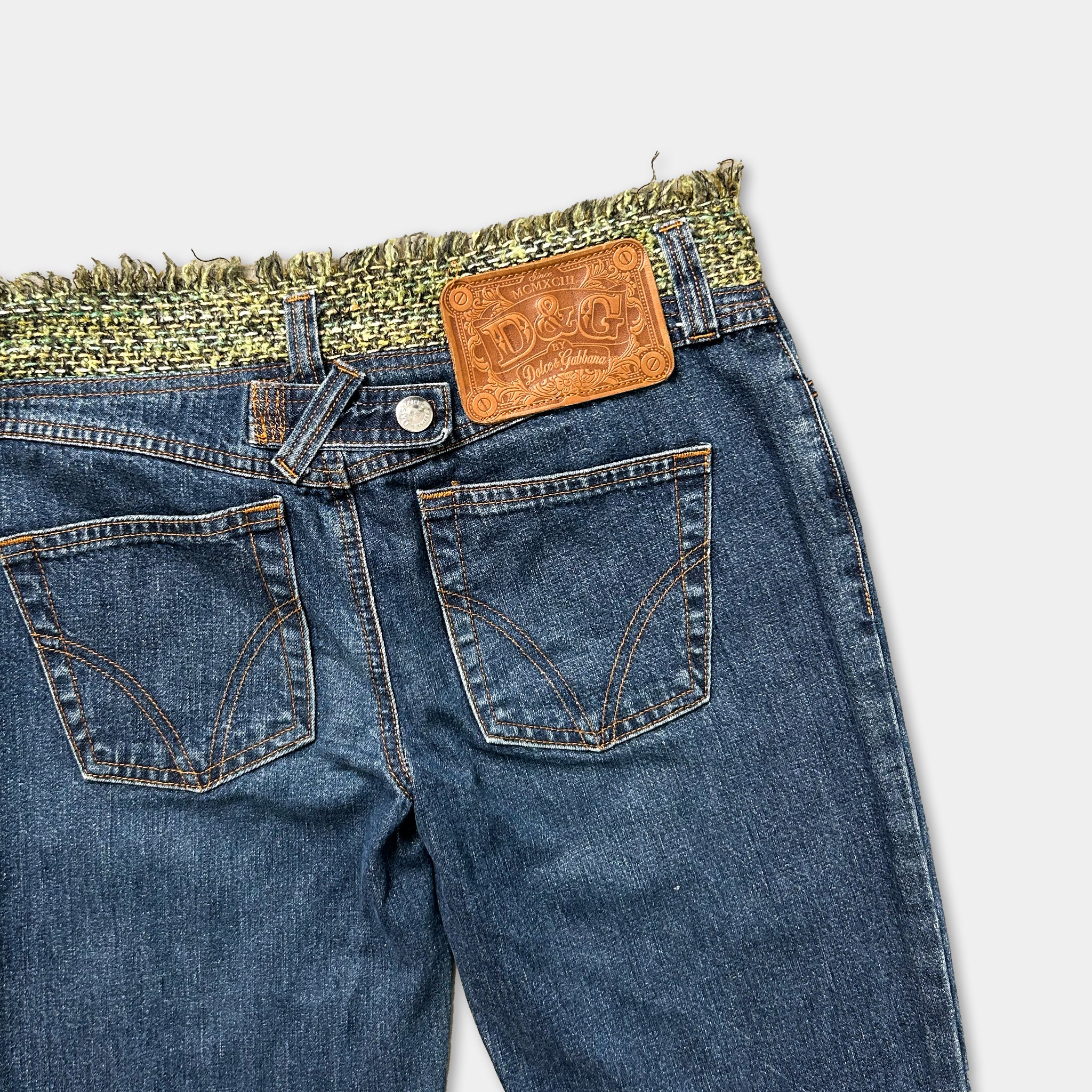 A pair of blue jeans with a brown leather patch on the back pocket.
