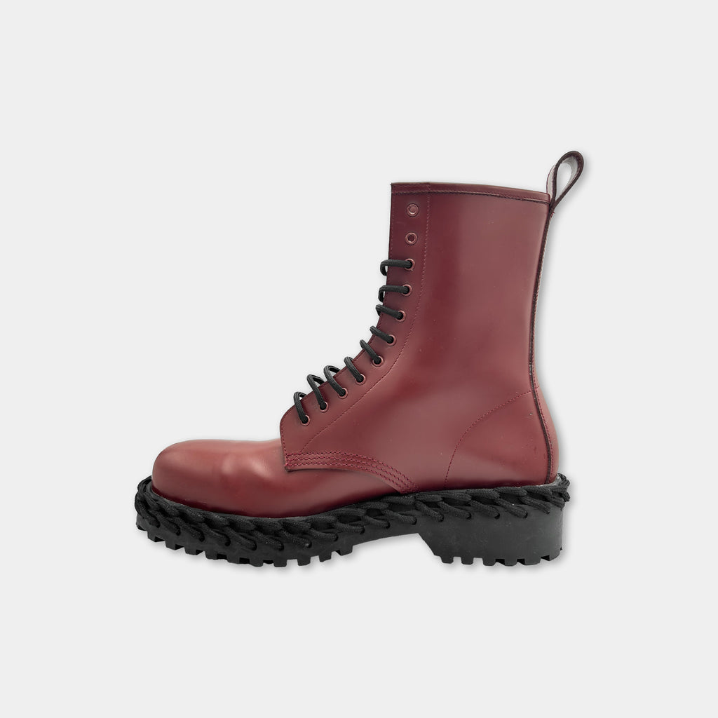 A red leather boot with a thick rubber sole and a lace-up closure.