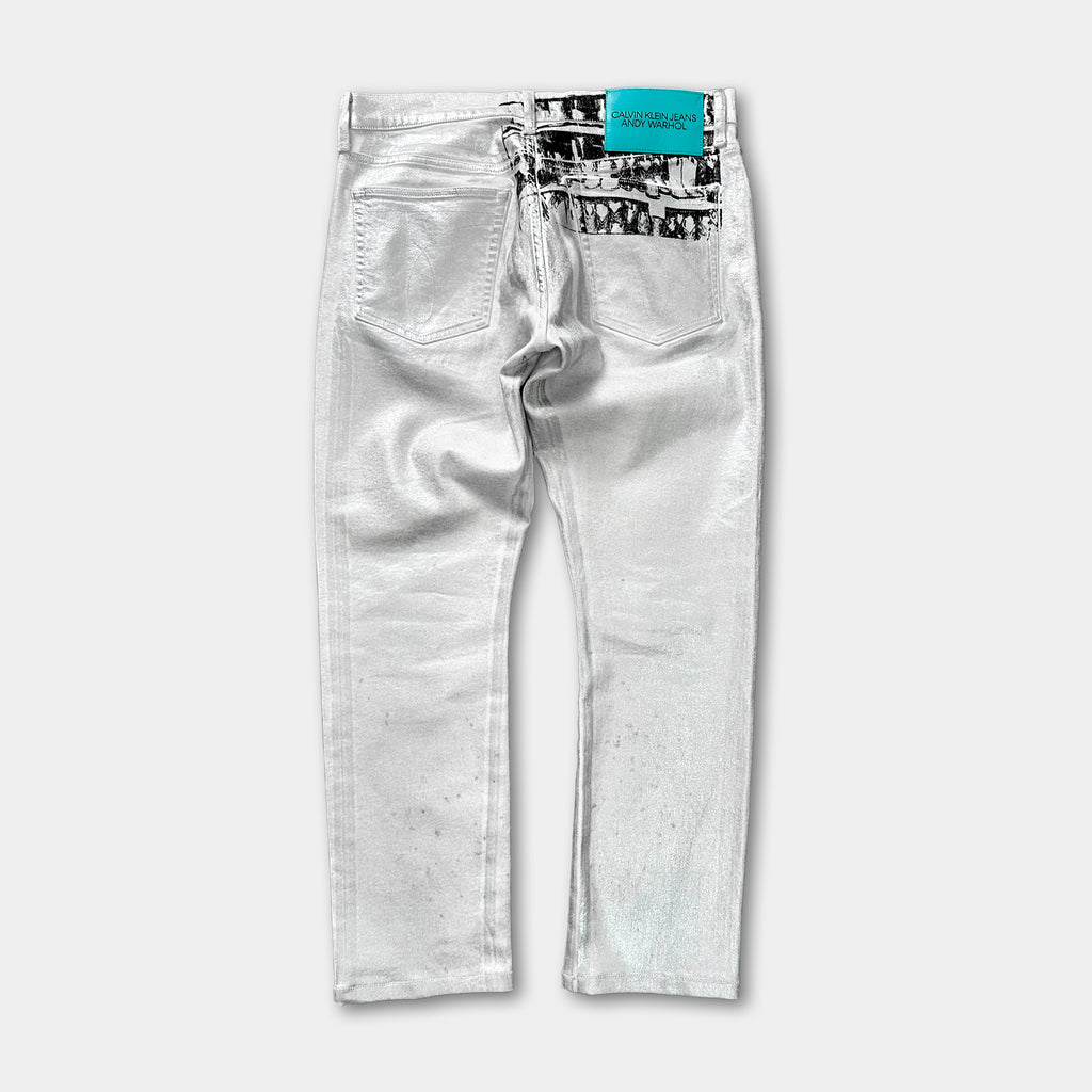 A pair of white jeans with a teal label on the back pocket.