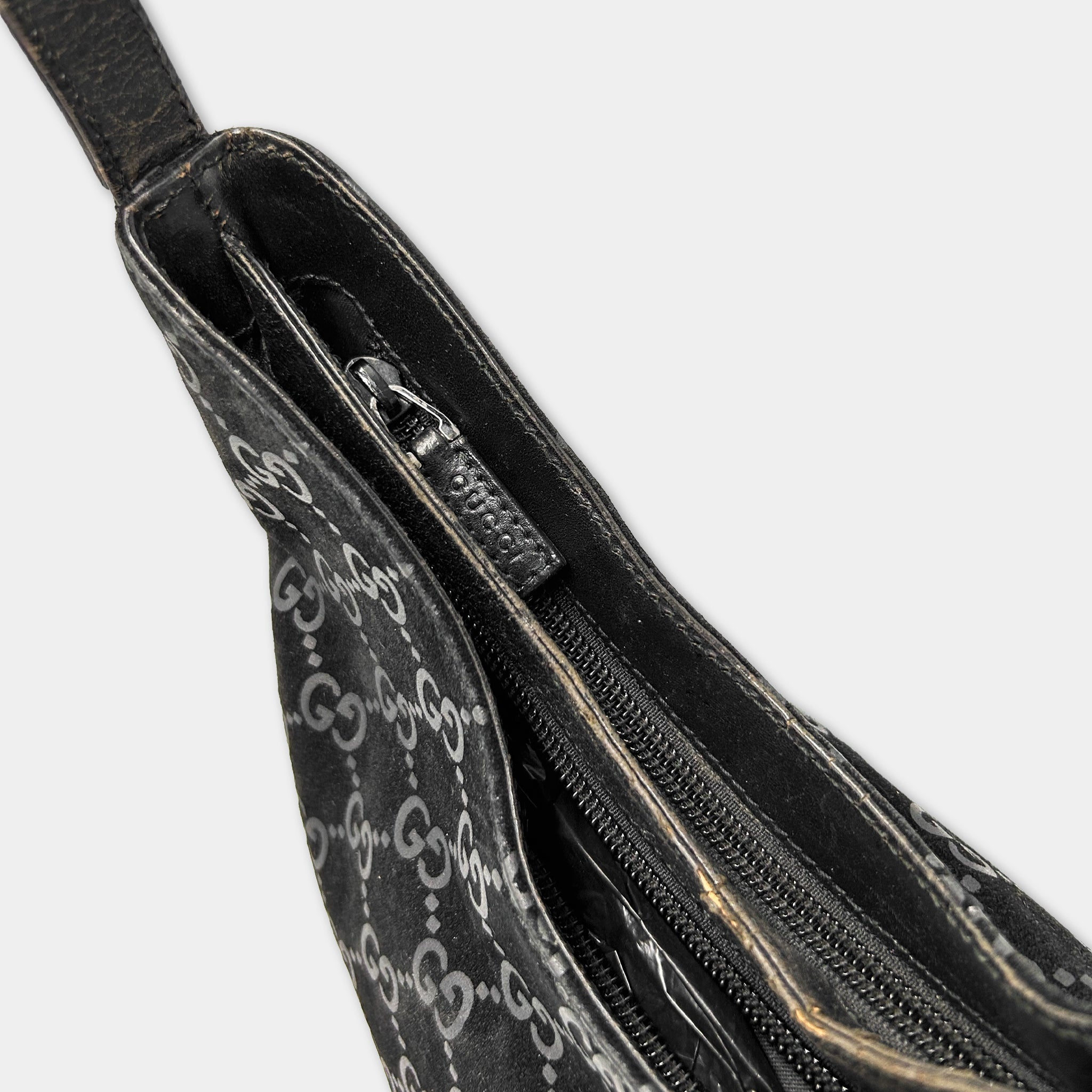 A close-up view of a black Gucci handbag with a distinctive white pattern.