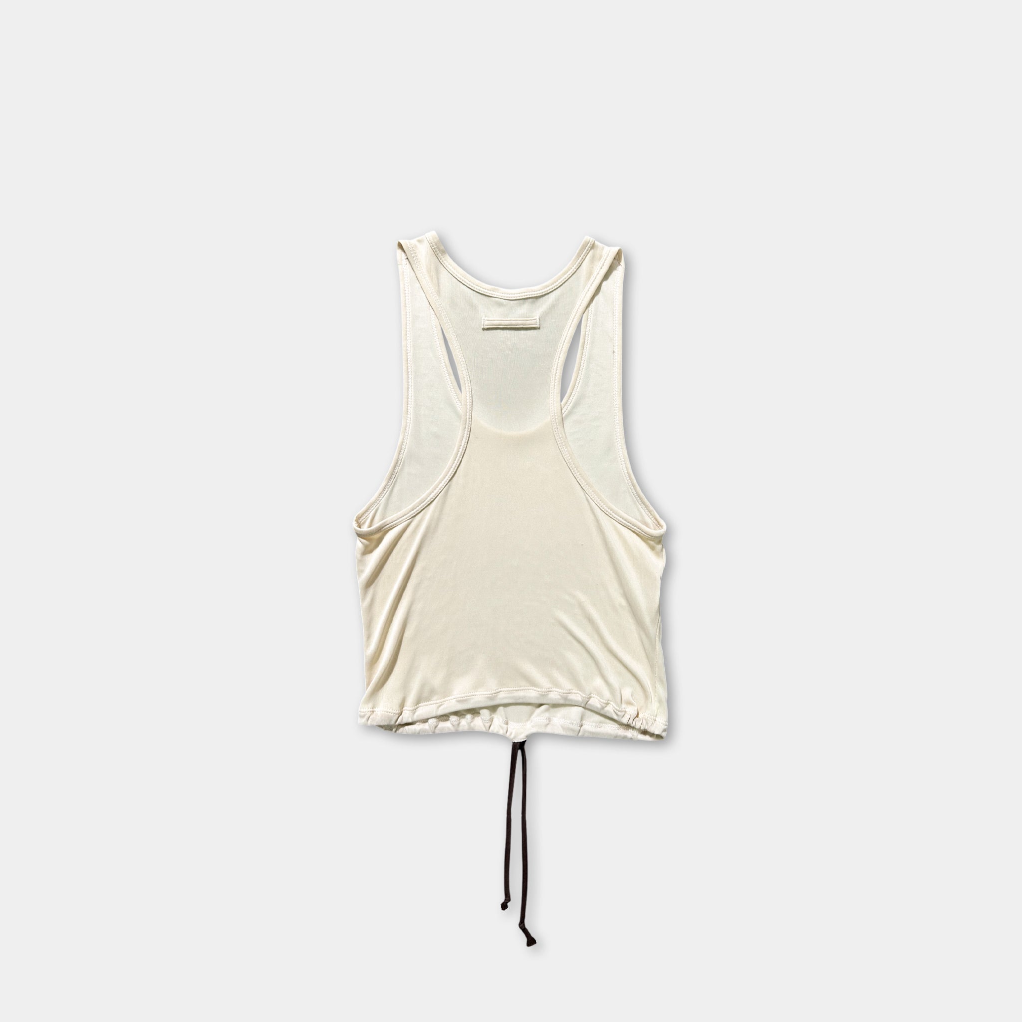 A white sleeveless top with a drawstring waist and a black tie at the bottom is shown against a plain white background.