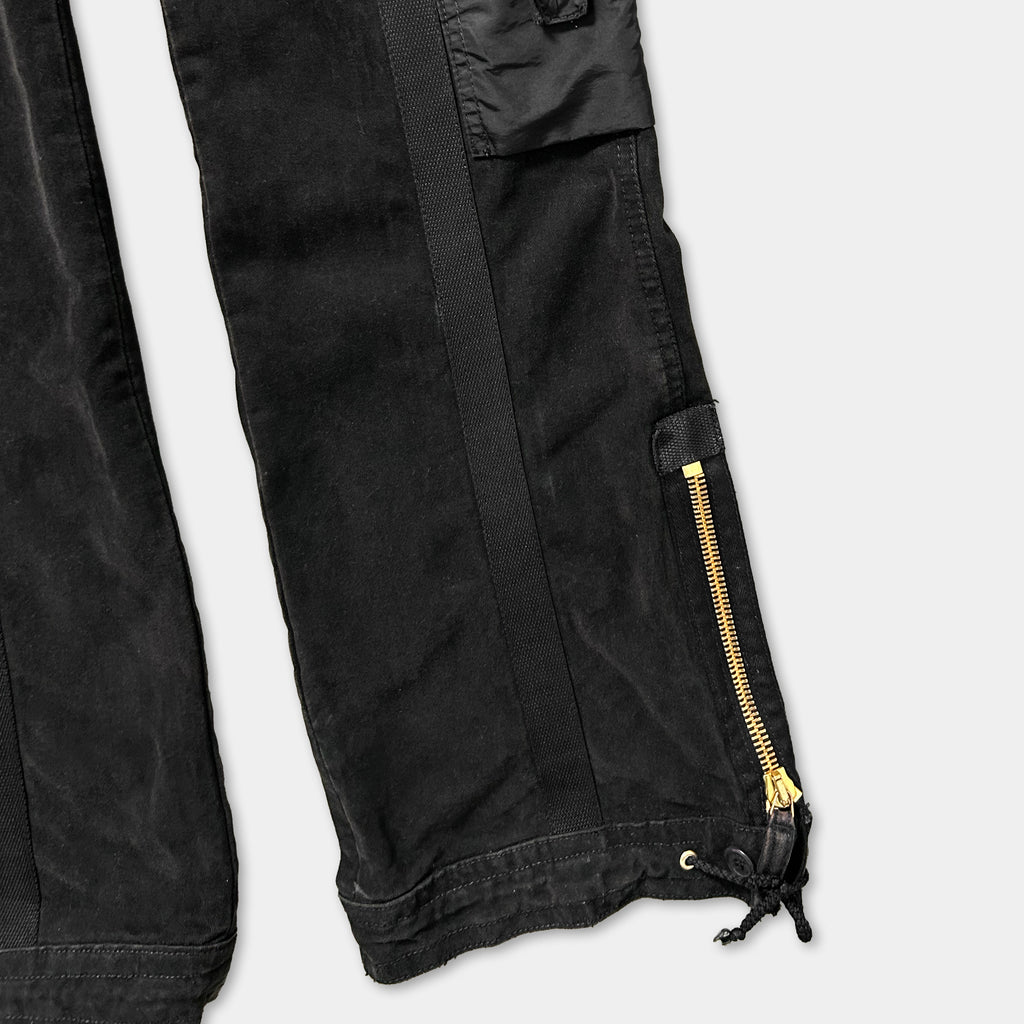 A close-up view of a pair of black cargo pants with a zipper detail.