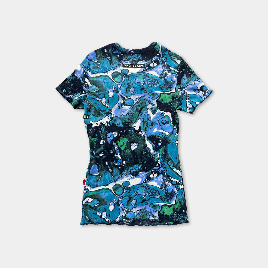 a colorful, abstract patterned t-shirt with a mix of blue, green, and white colors.