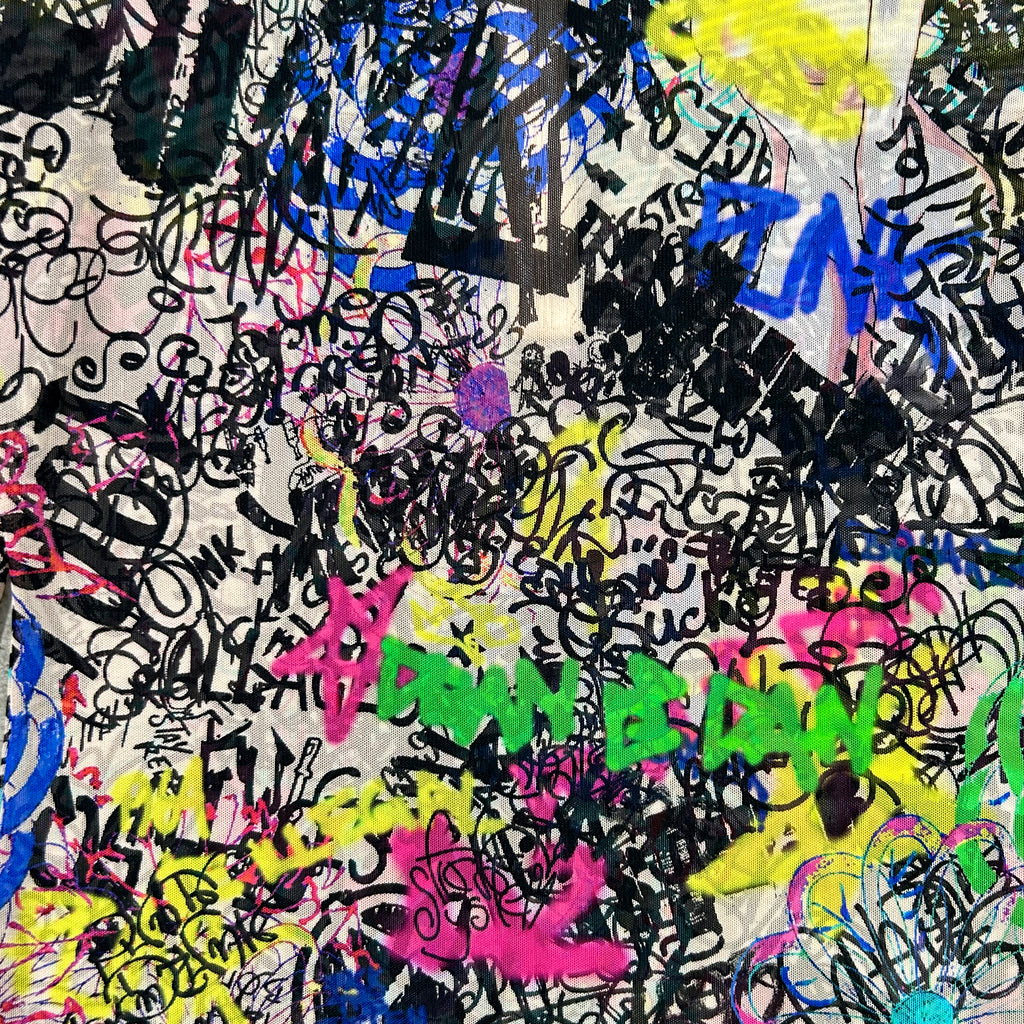 The image is a collage of various colorful graffiti-style tags and markings in different colors, including black, pink, yellow, blue, and green. The text and symbols are scattered throughout the image, creating a visually striking and chaotic composition.