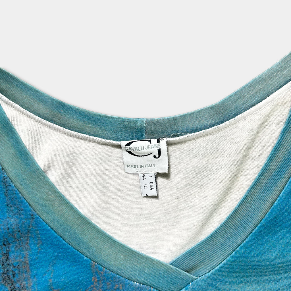 A close-up view of a blue and white v-neck top, with a label indicating it is made in Italy.