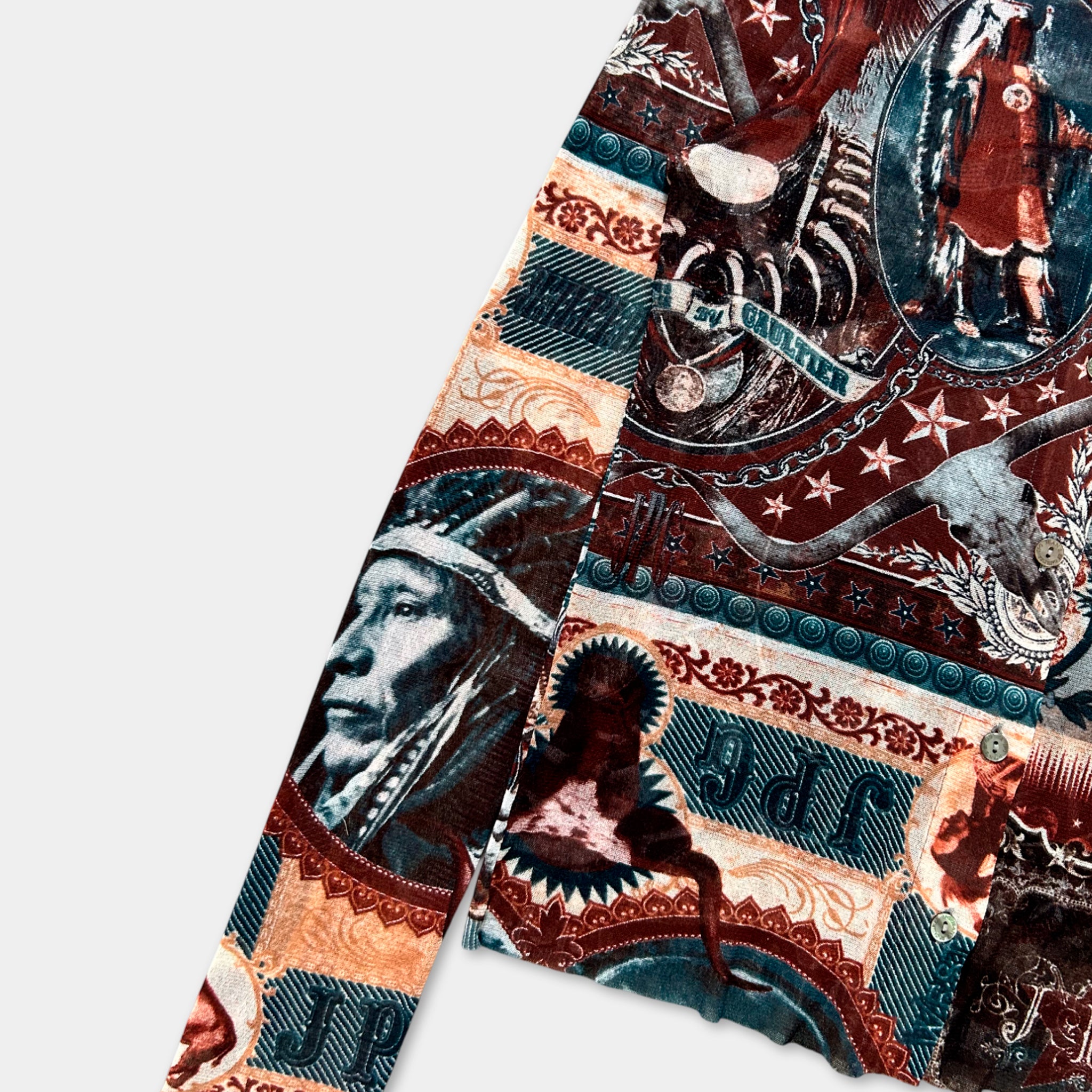 The image is a colorful, patterned fabric with various designs and images, including a Native American headdress, a skull, and other wildlife-inspired elements.