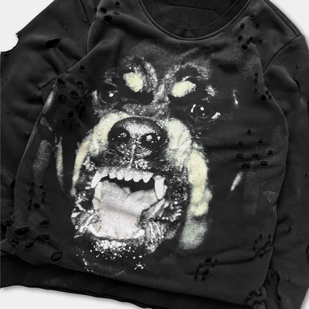 A close-up of a black and white image of a dog's face with its mouth open, giving the impression of a snarling or growling expression.