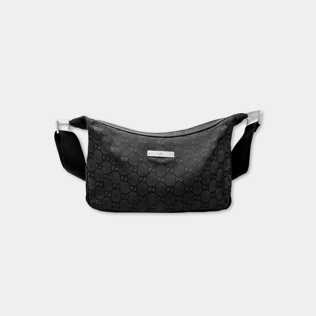 A black Gucci-patterned bag with a metal clasp and strap.