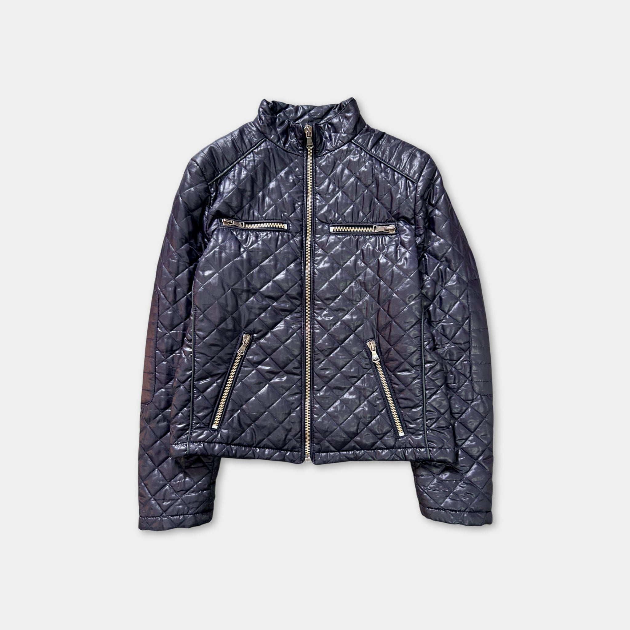 A black quilted jacket with a zipper and two pockets, displayed against a white background.