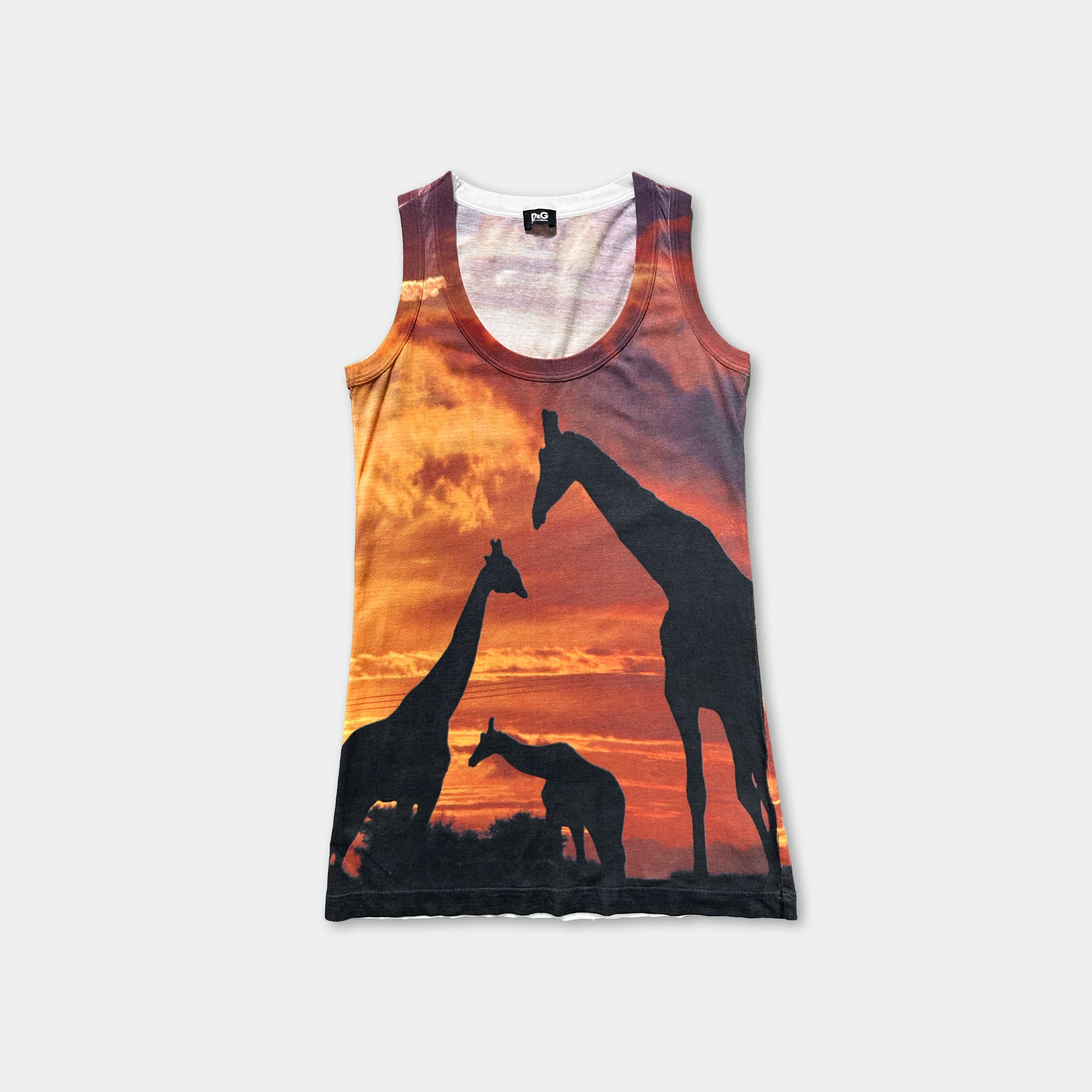 A tank top with a printed design depicting three giraffes silhouetted against a sunset sky.
