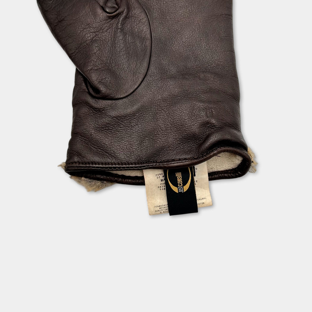A close-up view of a brown leather glove with a label attached to it.
