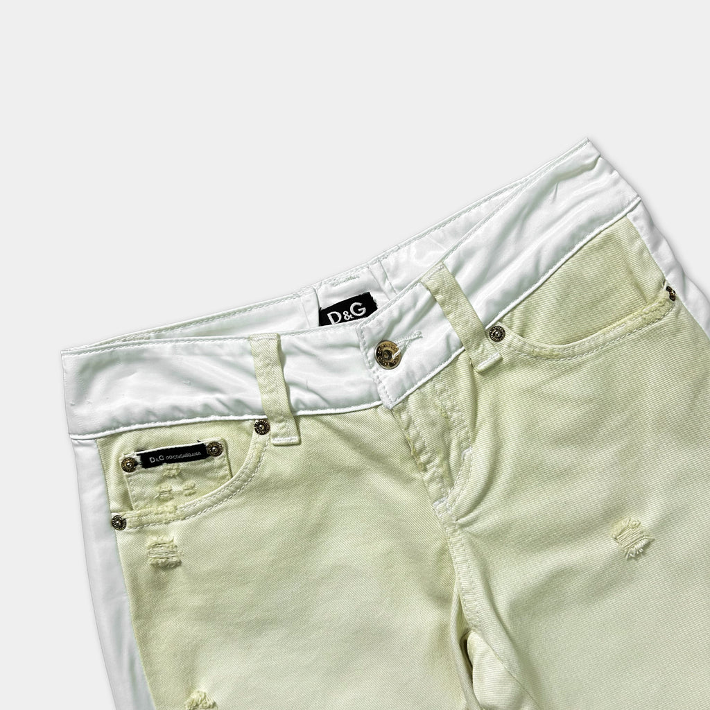 A pair of white and beige denim jeans with a white belt and a small tag on the waistband.