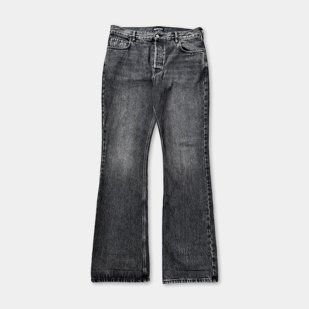 A pair of black jeans with a bell-shaped leg and a button closure.