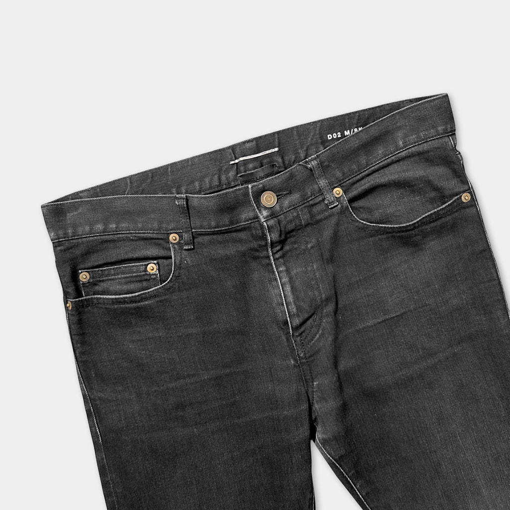 A pair of black skinny jeans with a zipper and pocket.