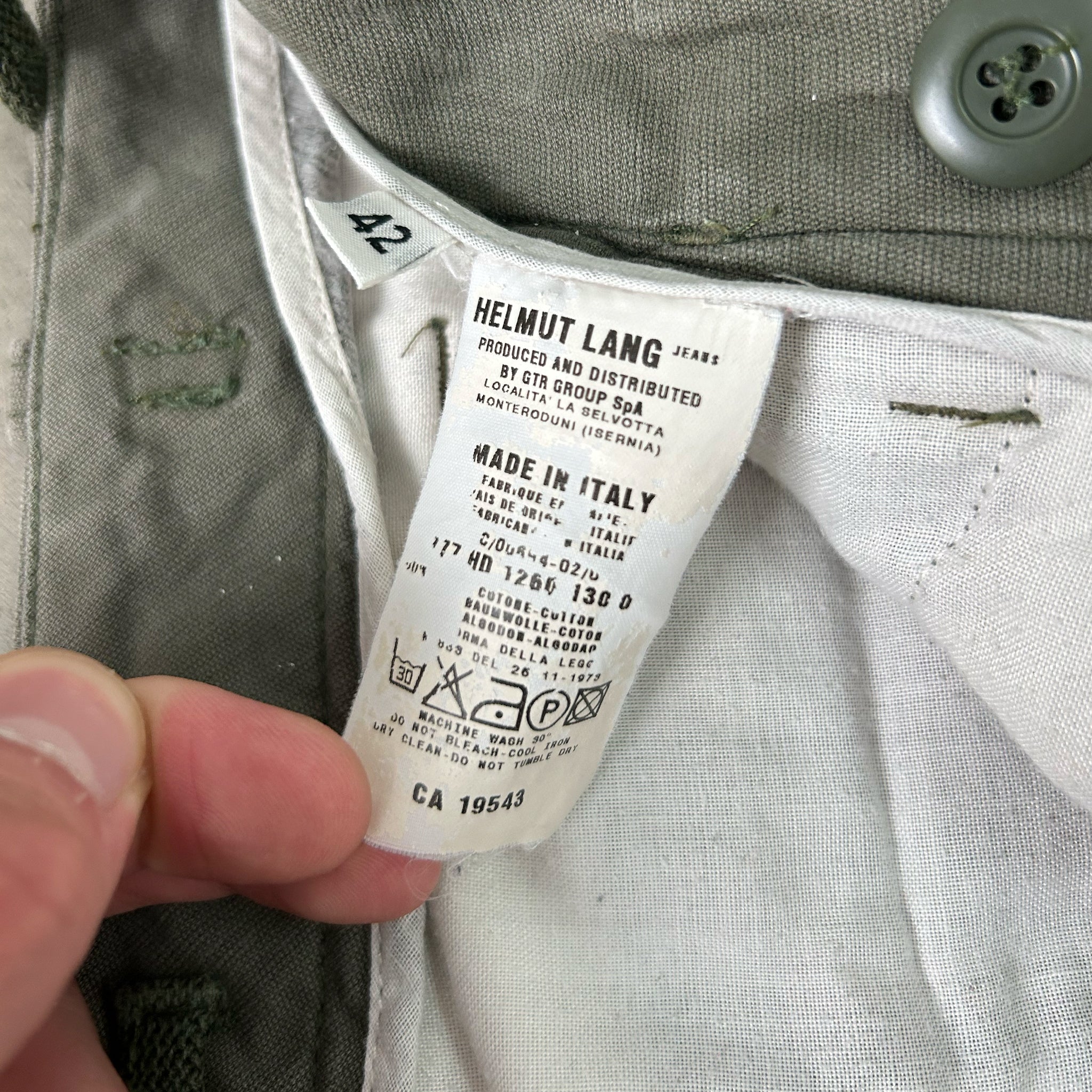 A close-up view of a clothing label, specifically a pair of jeans, with the brand name "Helmut Lang" printed on it.