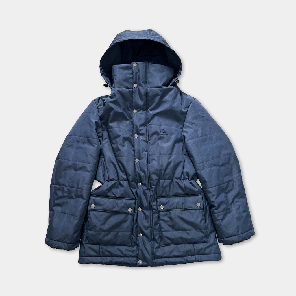 A navy blue puffer jacket with a hood and multiple pockets, displayed against a white background.