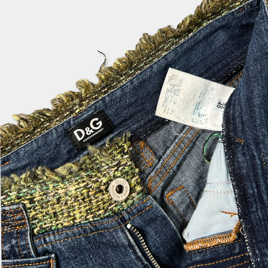 A close-up view of a pair of blue jeans with a label and a zipper pull visible.