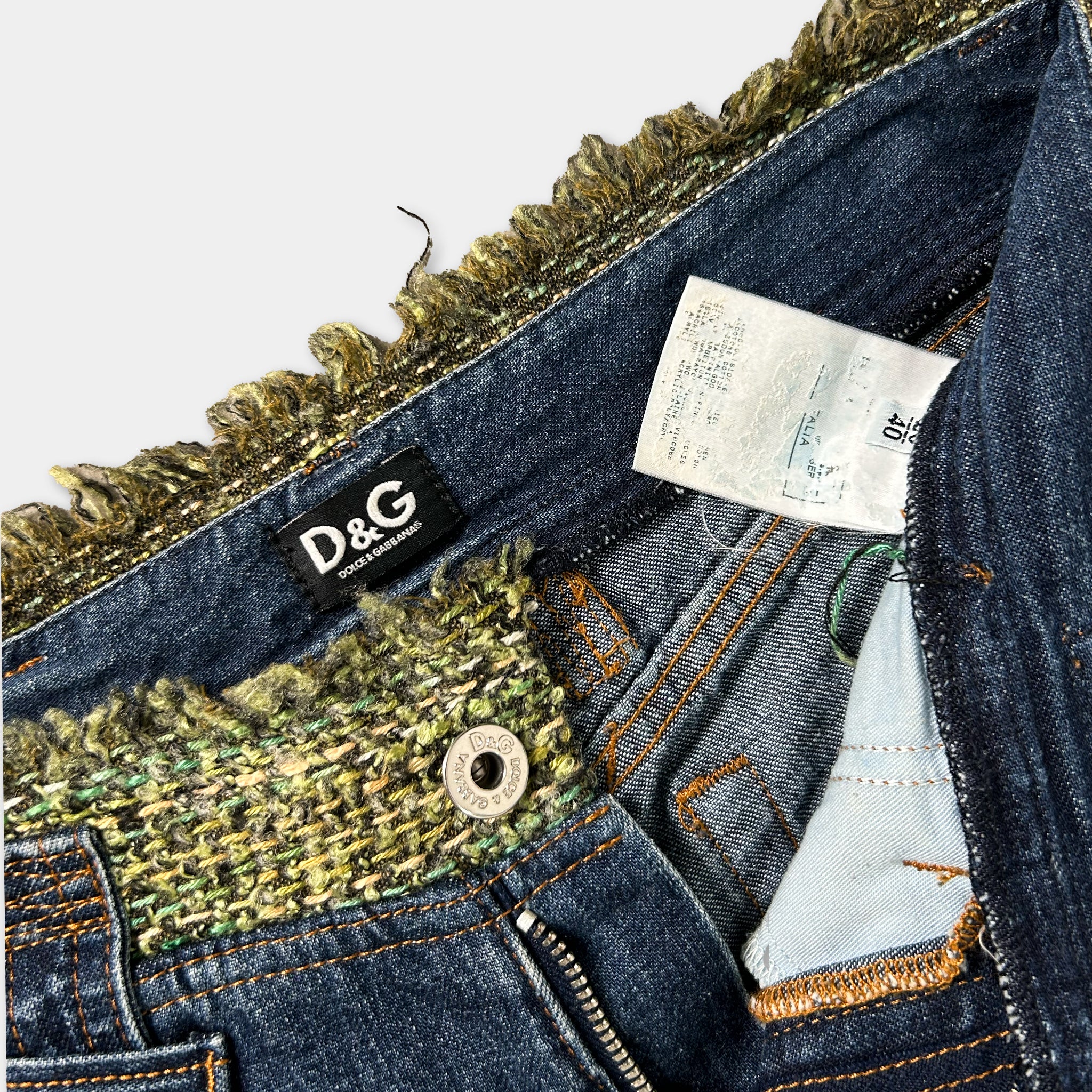 A close-up view of a pair of blue jeans with a label and a zipper pull visible.