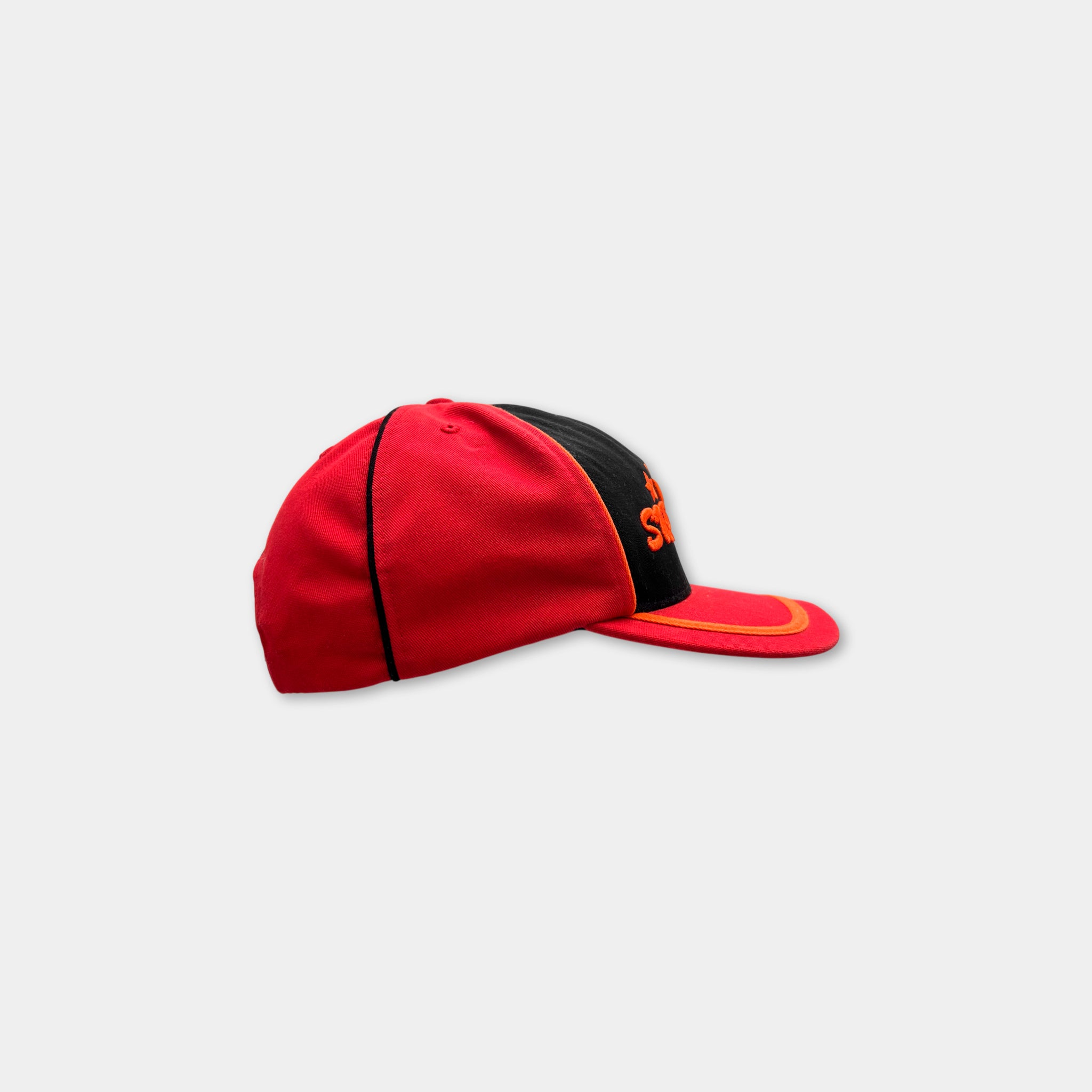 A red baseball cap with a black brim and orange trim.