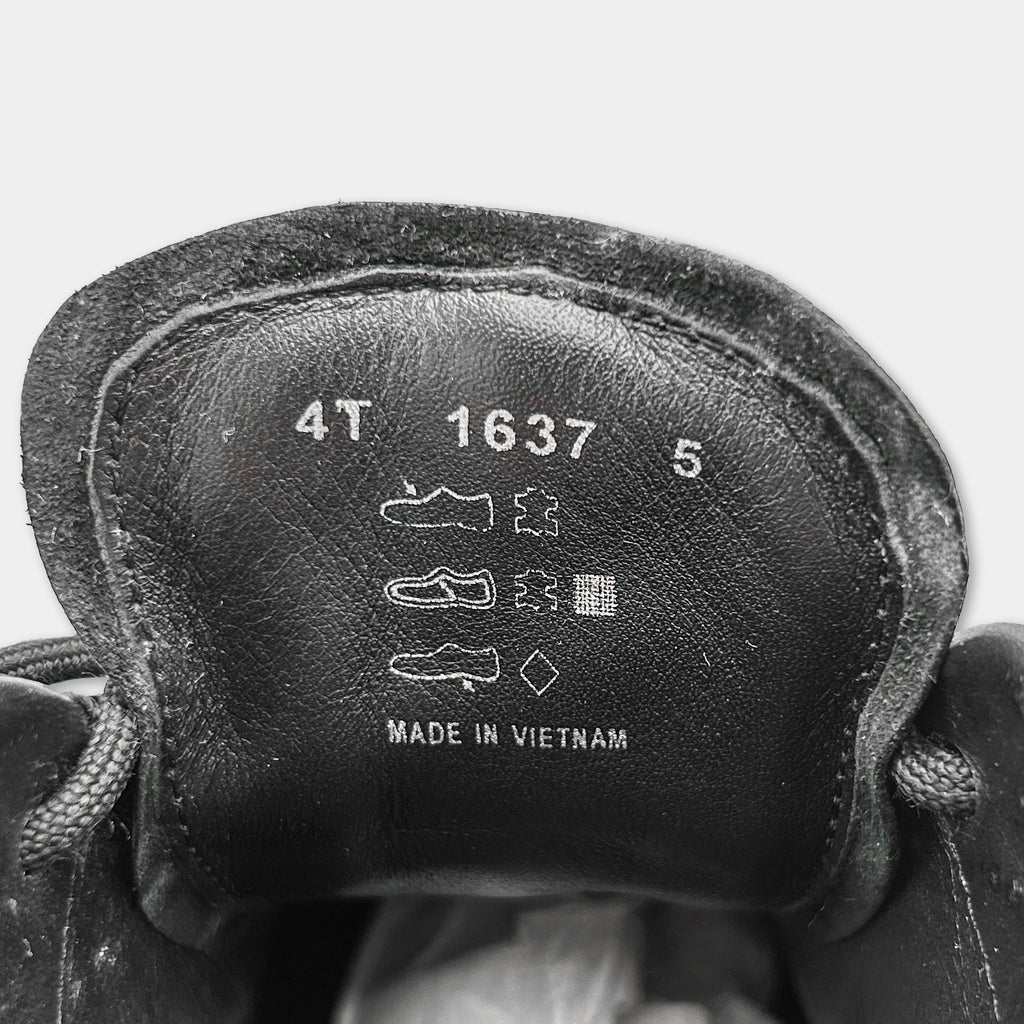 the interior of a black shoe, specifically the sole and the upper part. The text on the shoe indicates that it is made in Vietnam.