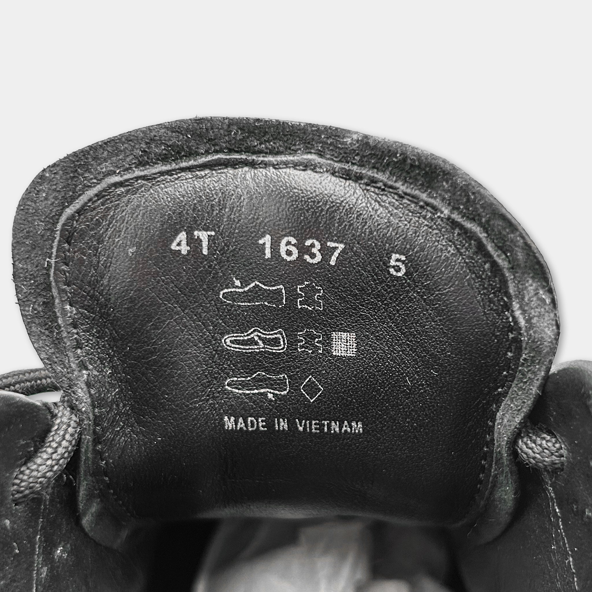 the interior of a black shoe, specifically the sole and the upper part. The text on the shoe indicates that it is made in Vietnam.