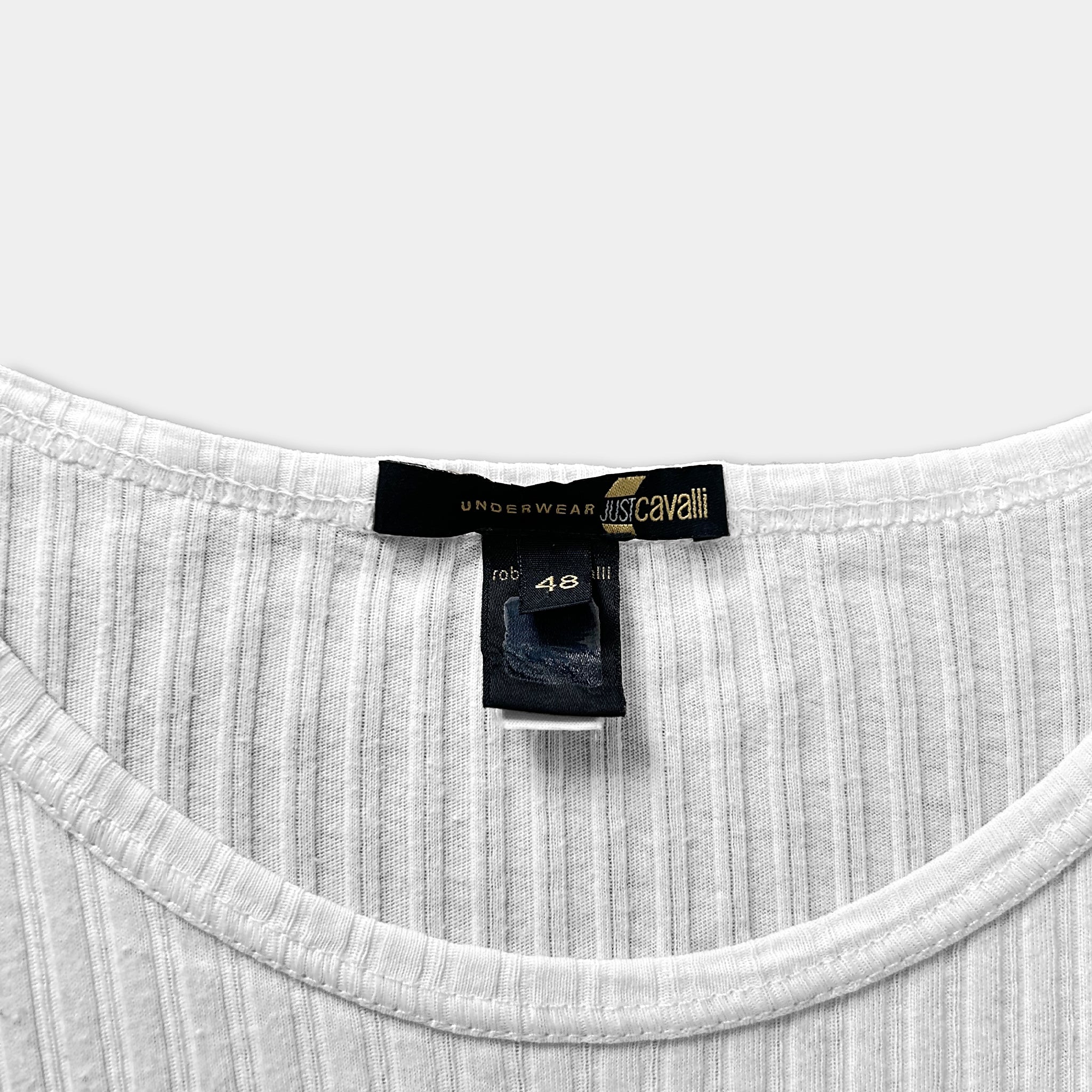 a close-up view of a white ribbed shirt with a label attached to it, indicating it is an Underwear item from the brand Just Cavalli.