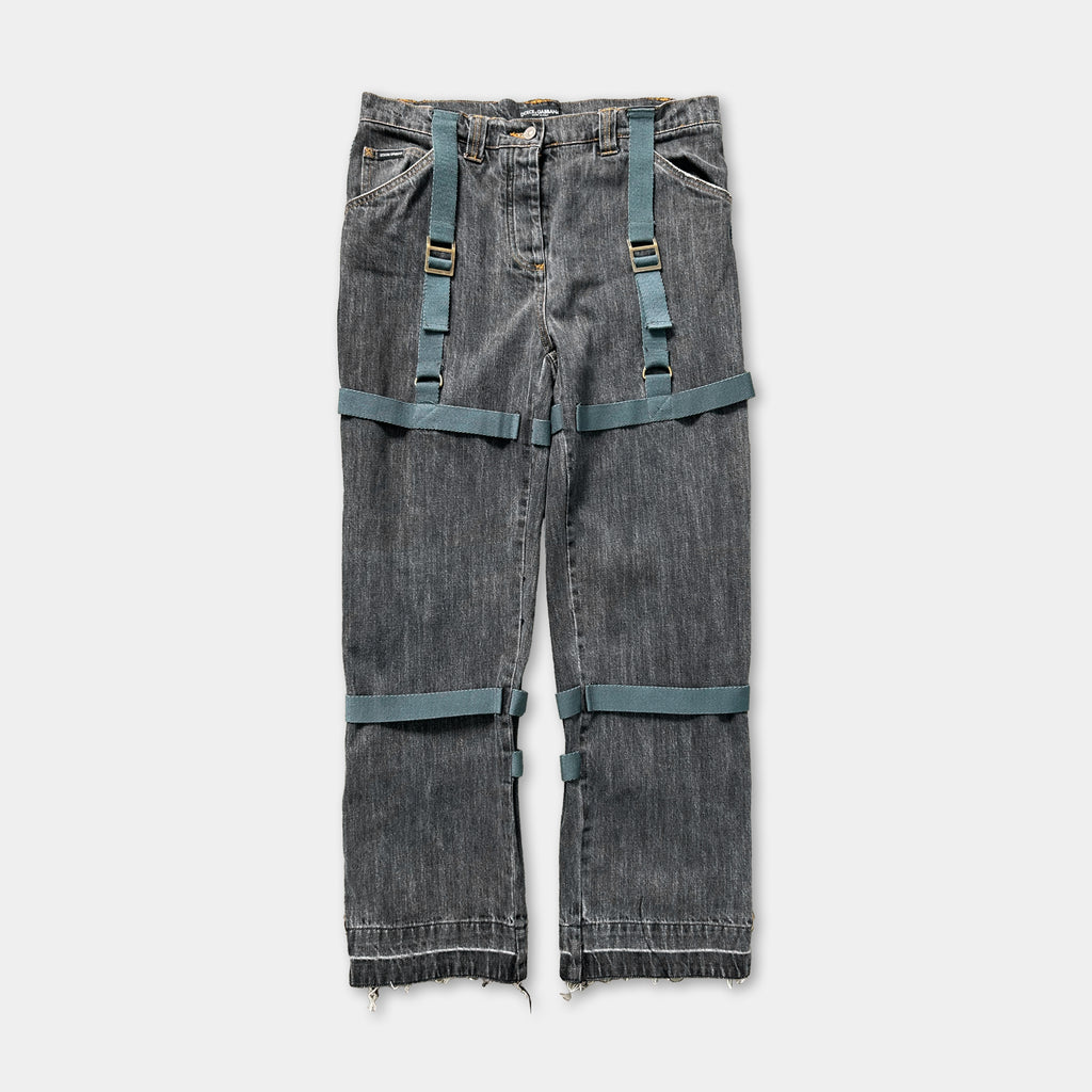 A pair of gray jeans with green straps, which appear to be designed for a unique and unconventional style.