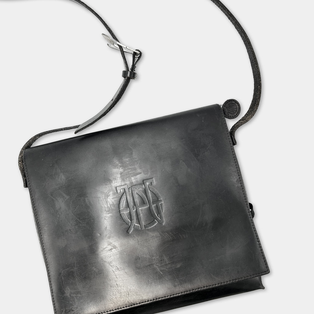A black leather handbag with a metal clasp and strap.