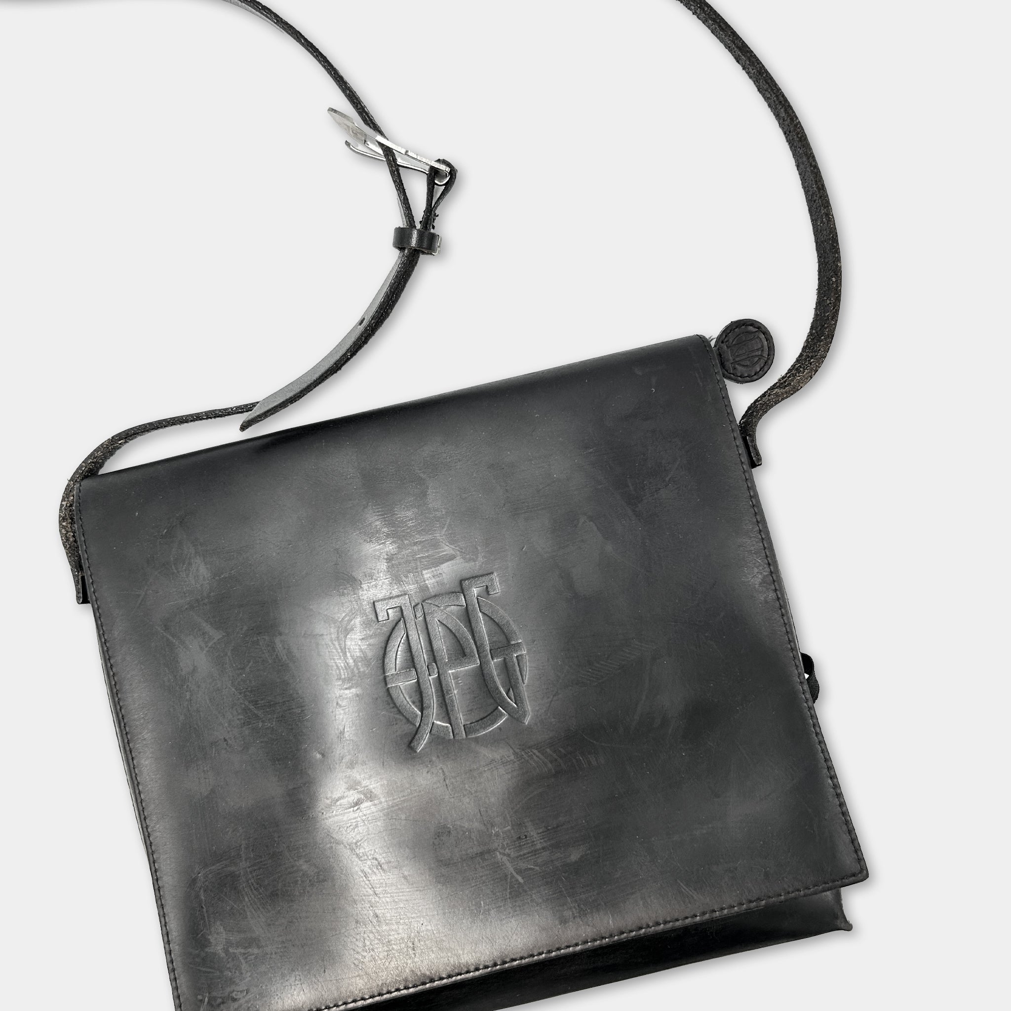 A black leather handbag with a metal clasp and strap.