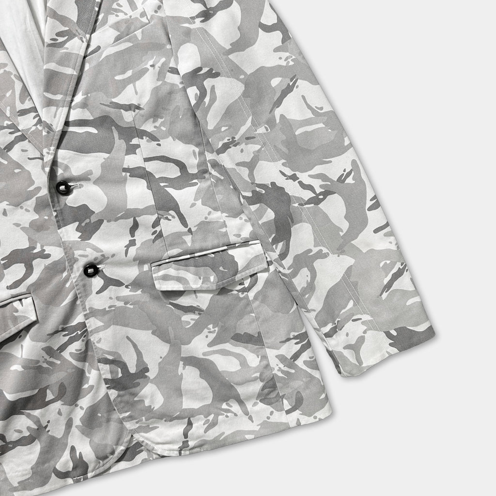 A close-up view of a camouflage-patterned jacket or blazer, with a white background.