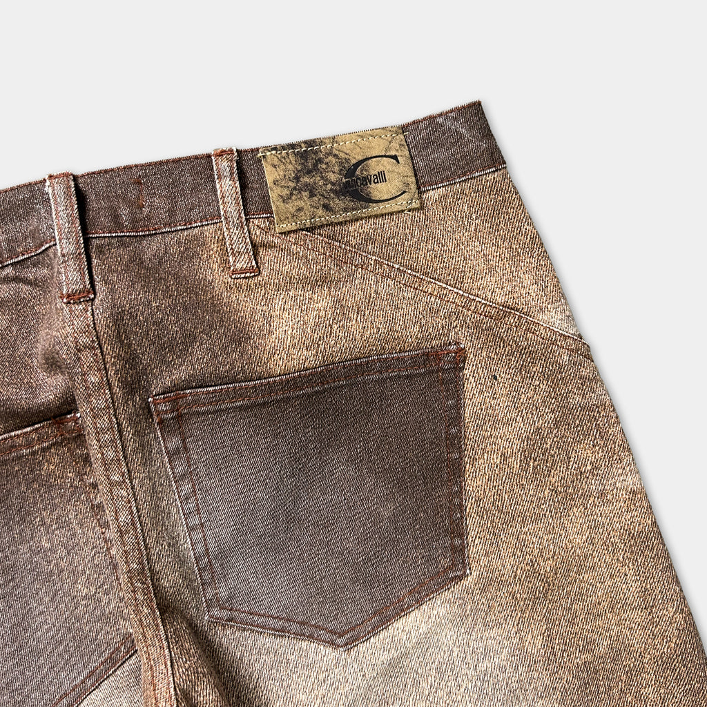 A close-up view of a pair of brown and tan jeans with a label on the back pocket.