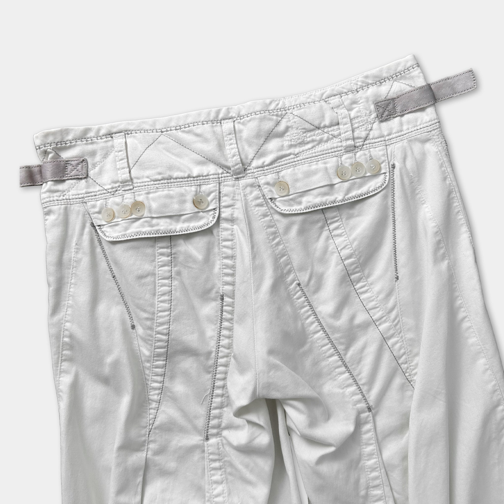 A pair of white pants with a zipper and button closure.