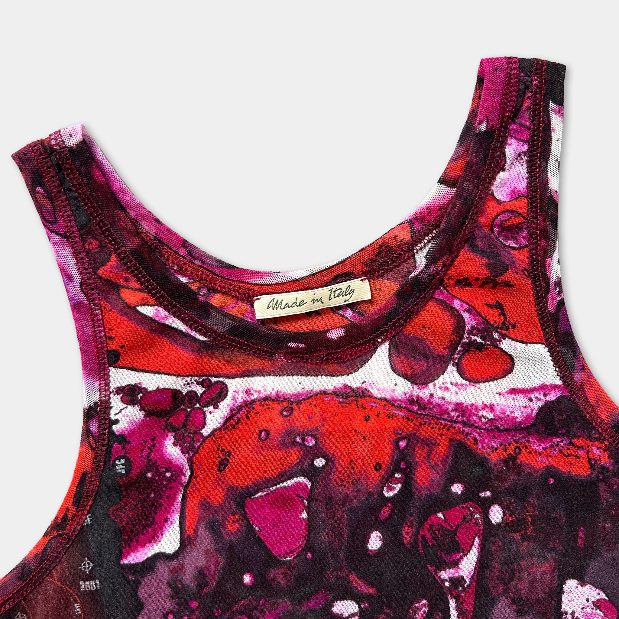 a close-up view of a colorful, abstract patterned tank top or sleeveless top with a label that reads "Made in Italy".