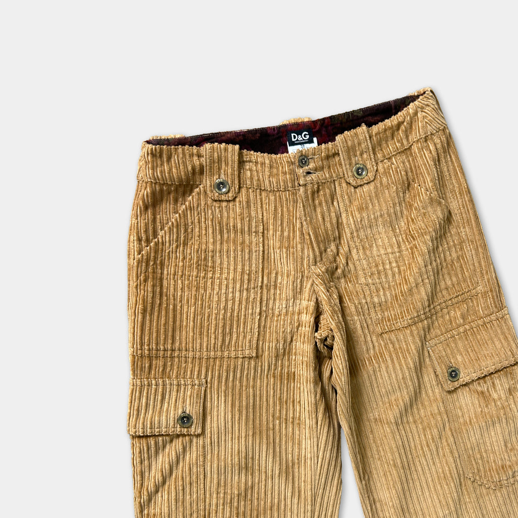 A pair of tan corduroy pants with pockets and buttons.