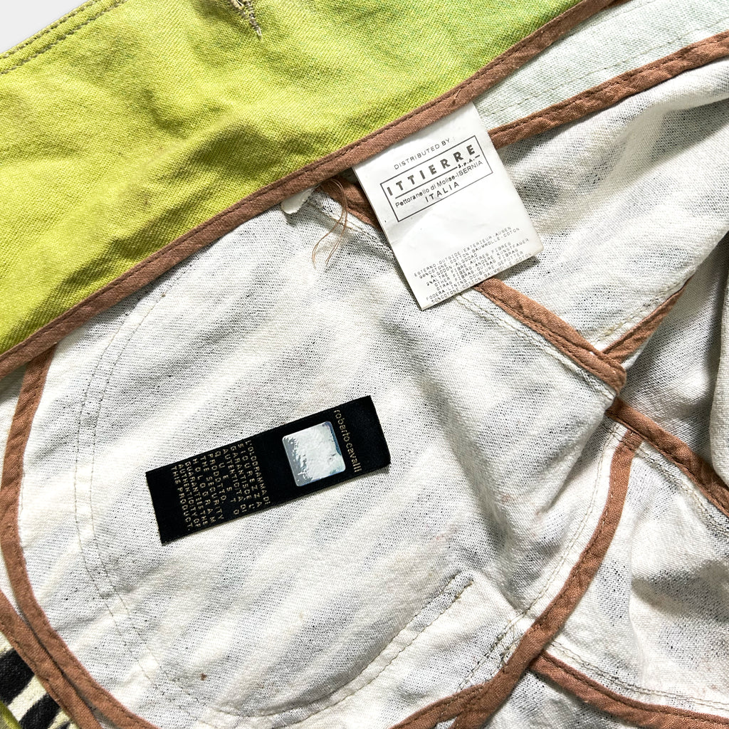 a close-up view of a piece of clothing with a label attached to it, placed on a surface with a green and brown color scheme.