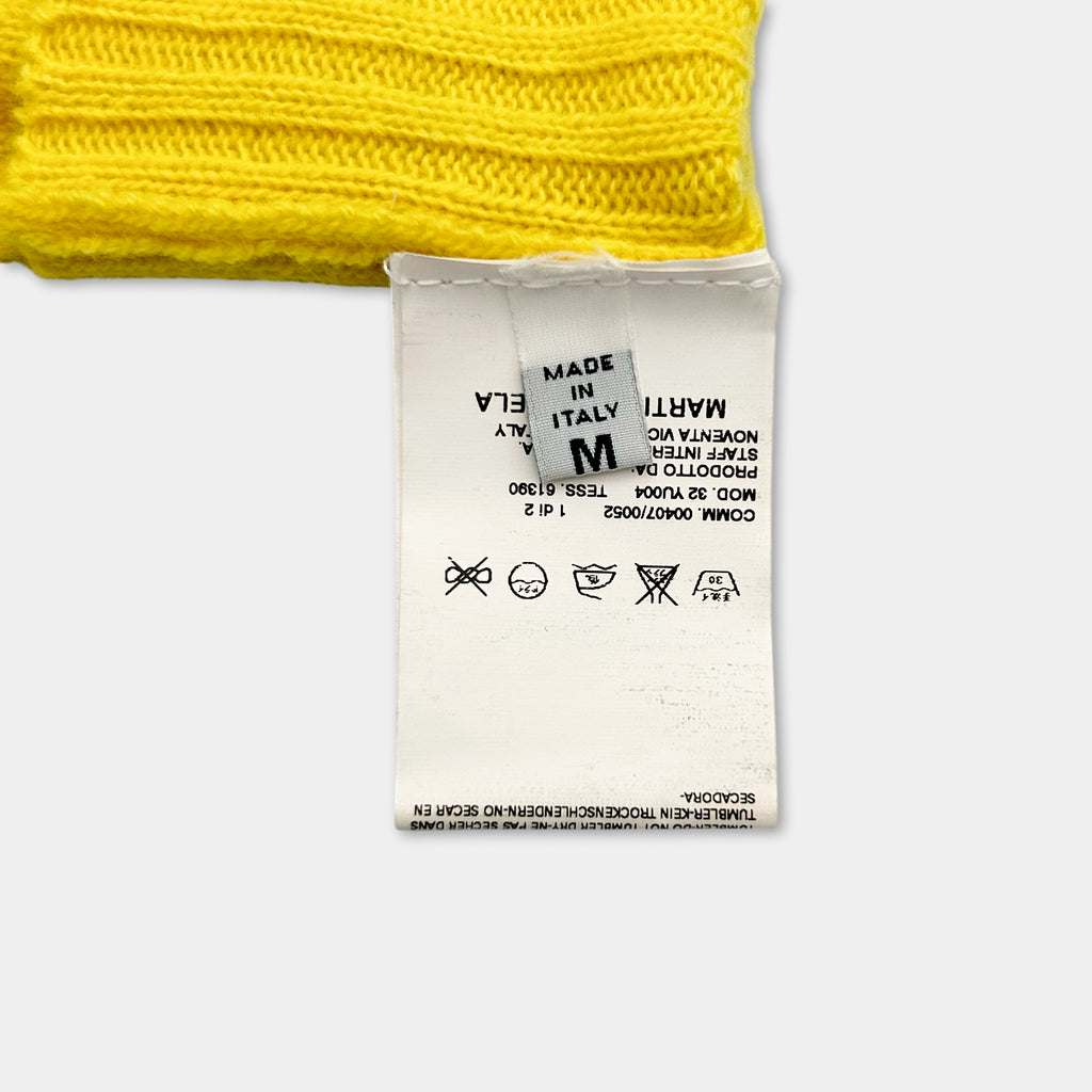 a yellow knitted item with a white label attached to it.