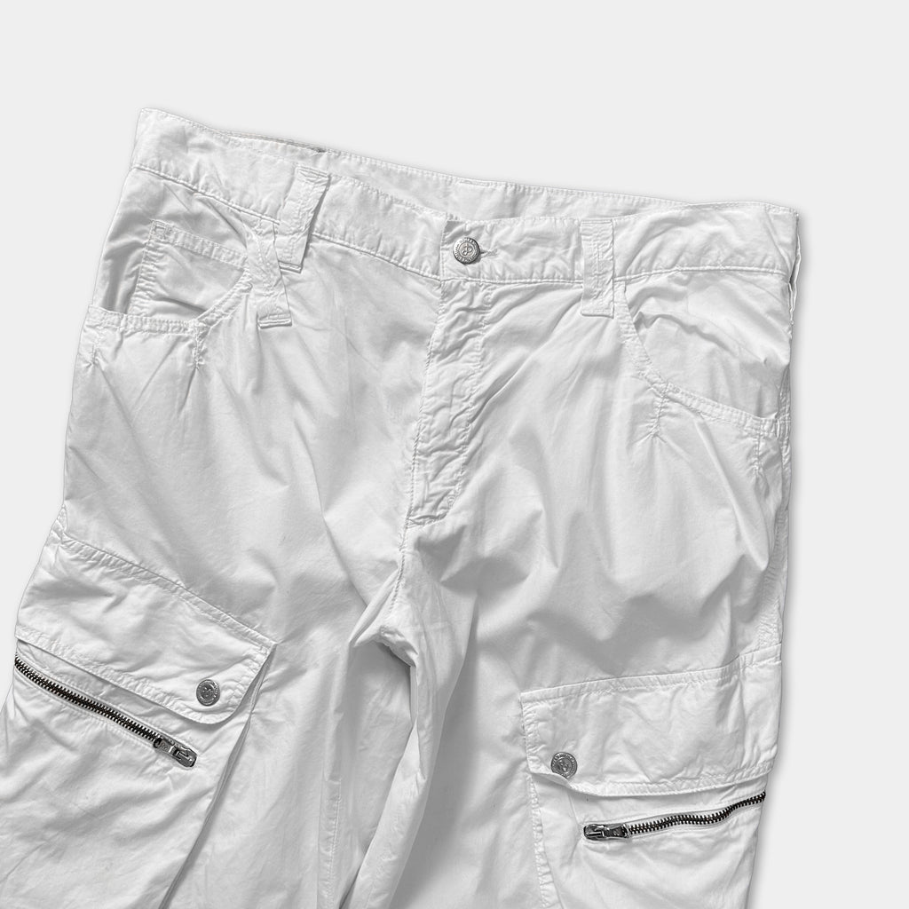 A pair of white cargo shorts with multiple pockets and zippers.