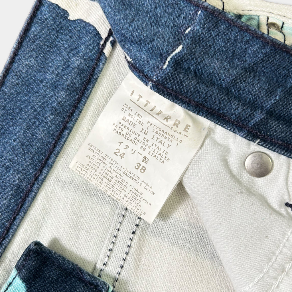 a close-up view of a denim fabric, specifically a pair of jeans, with a label attached to the waistband.