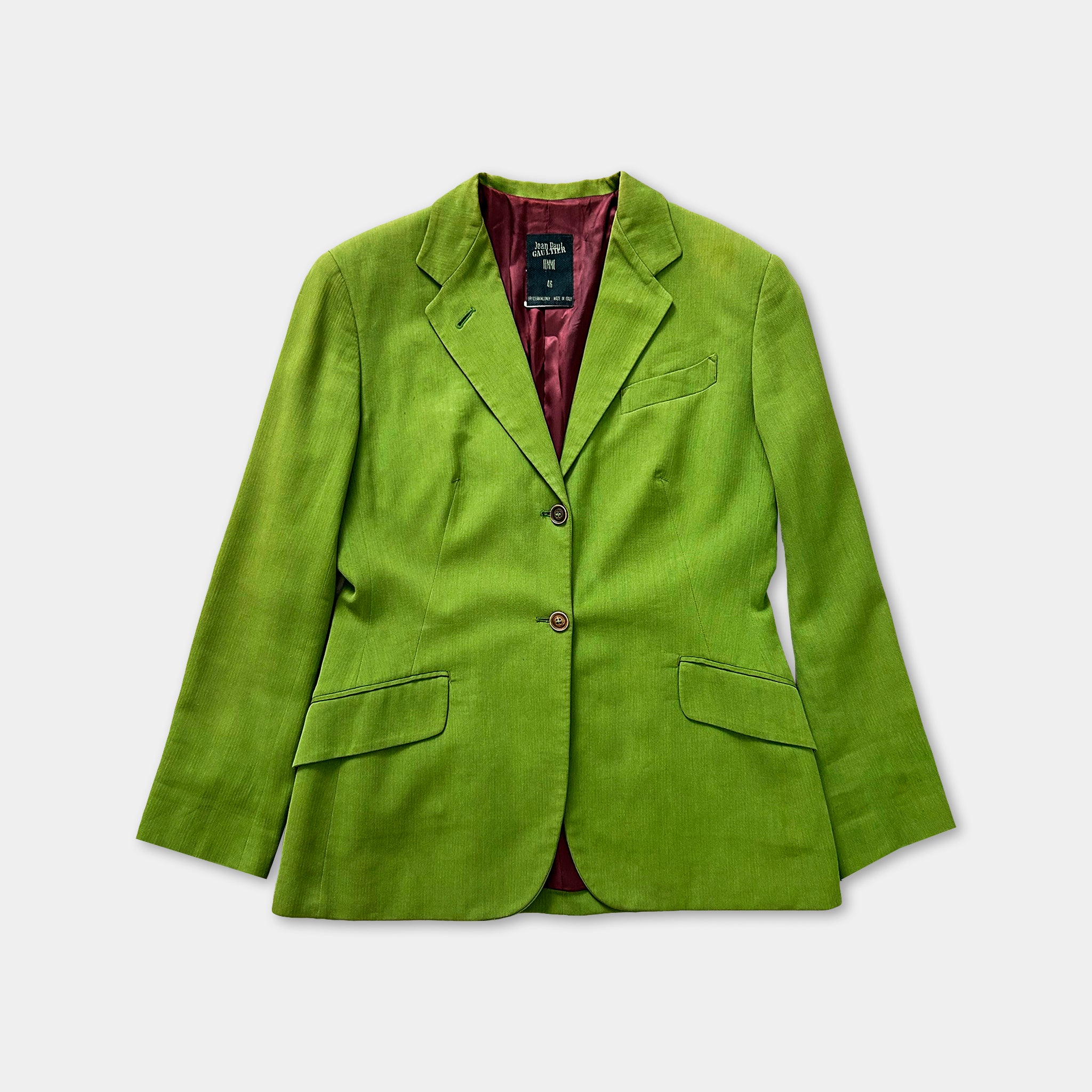 A bright green blazer with a maroon lining and buttons, displayed against a white background.
