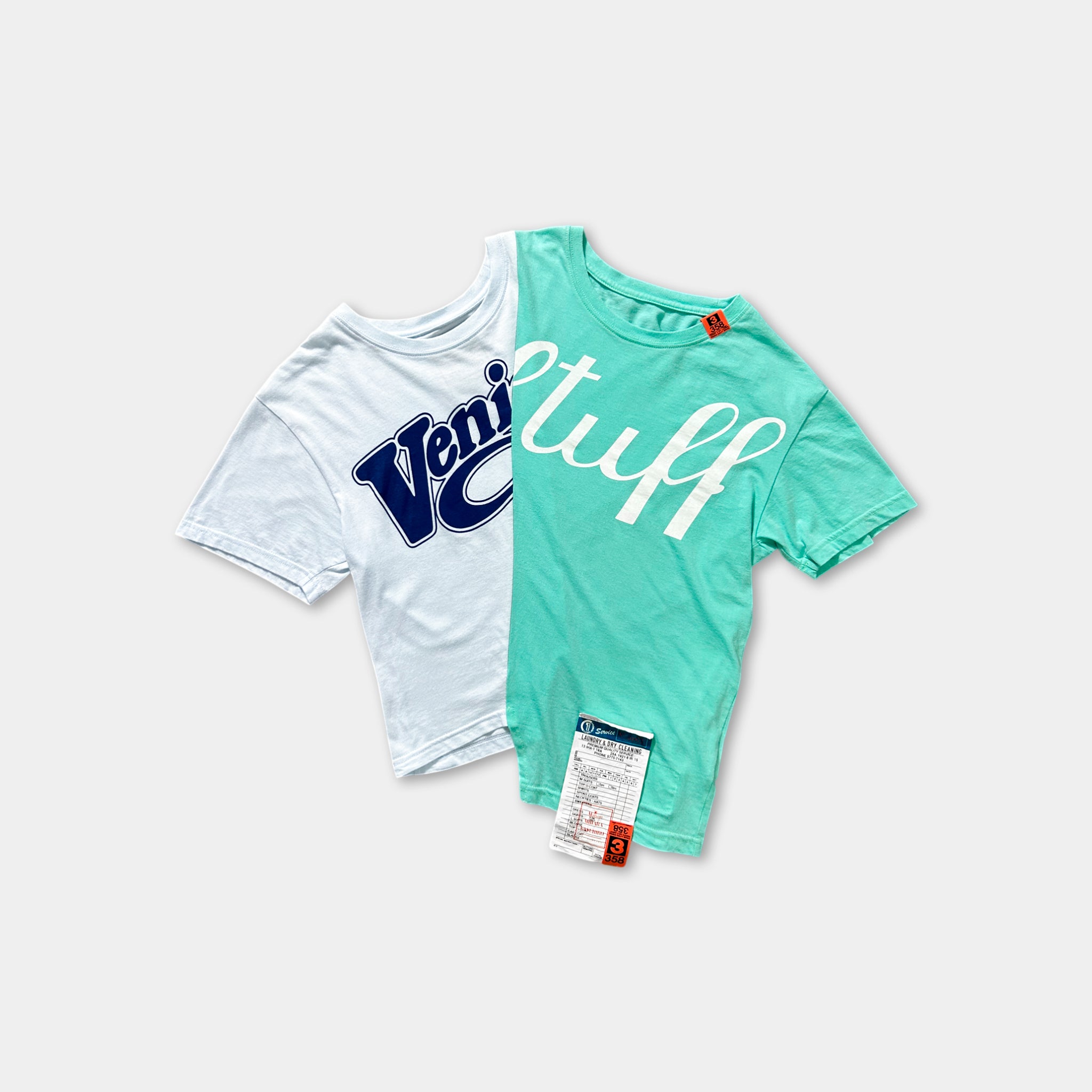 two t-shirts, one white and one mint green, with the mint green t-shirt having a tag attached to it.