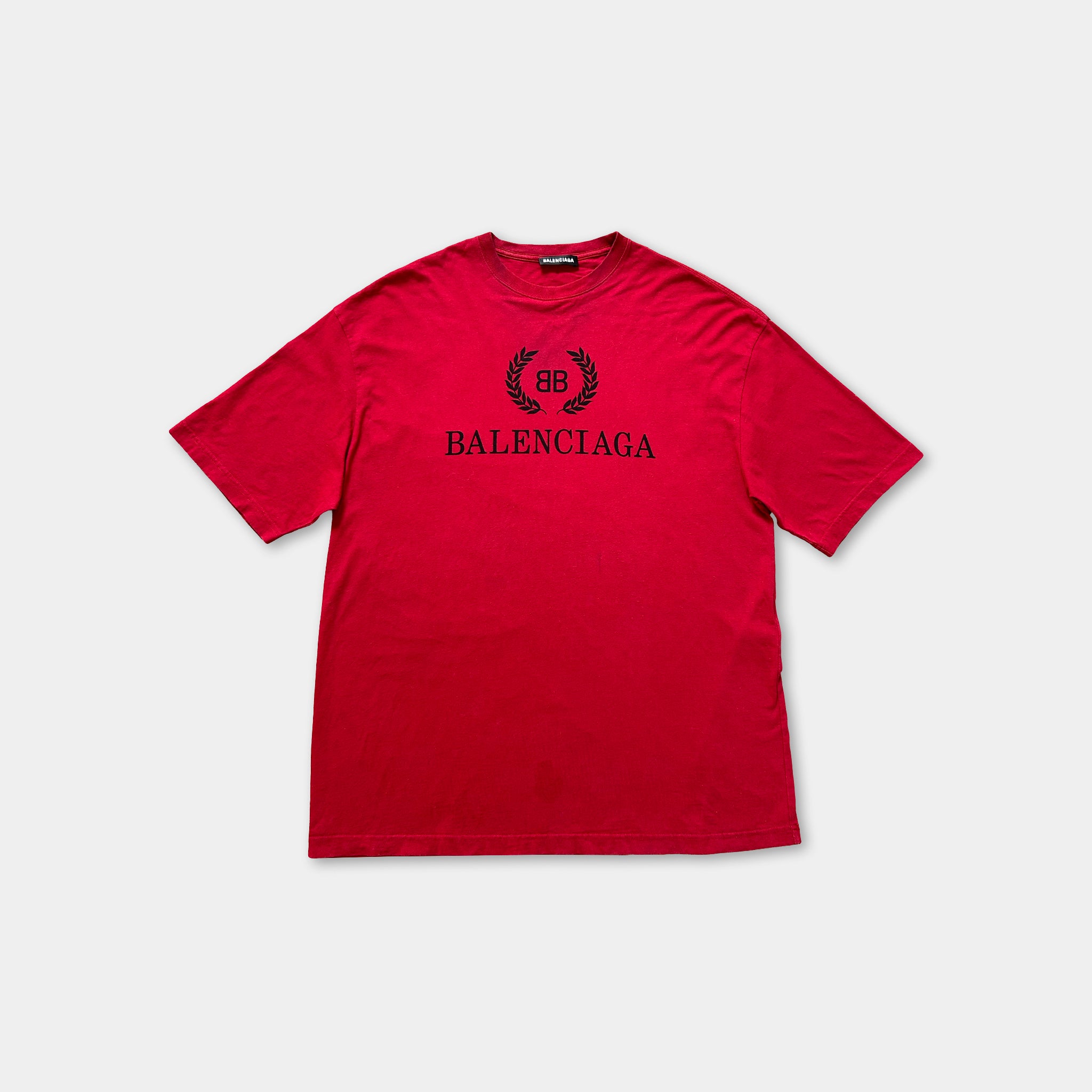 A red Balenciaga t-shirt with the Balenciaga logo printed on it.