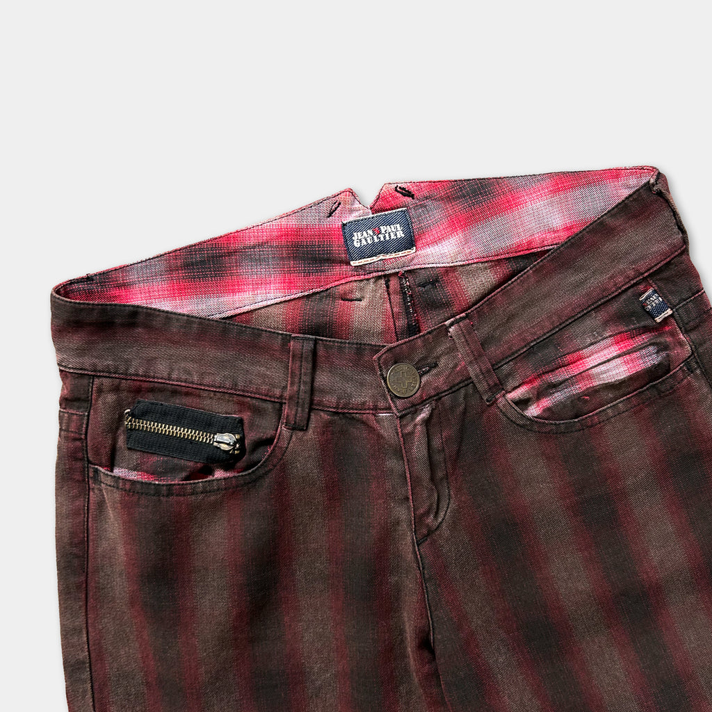 A pair of brown plaid jeans with a zipper pocket and a label on the waistband.