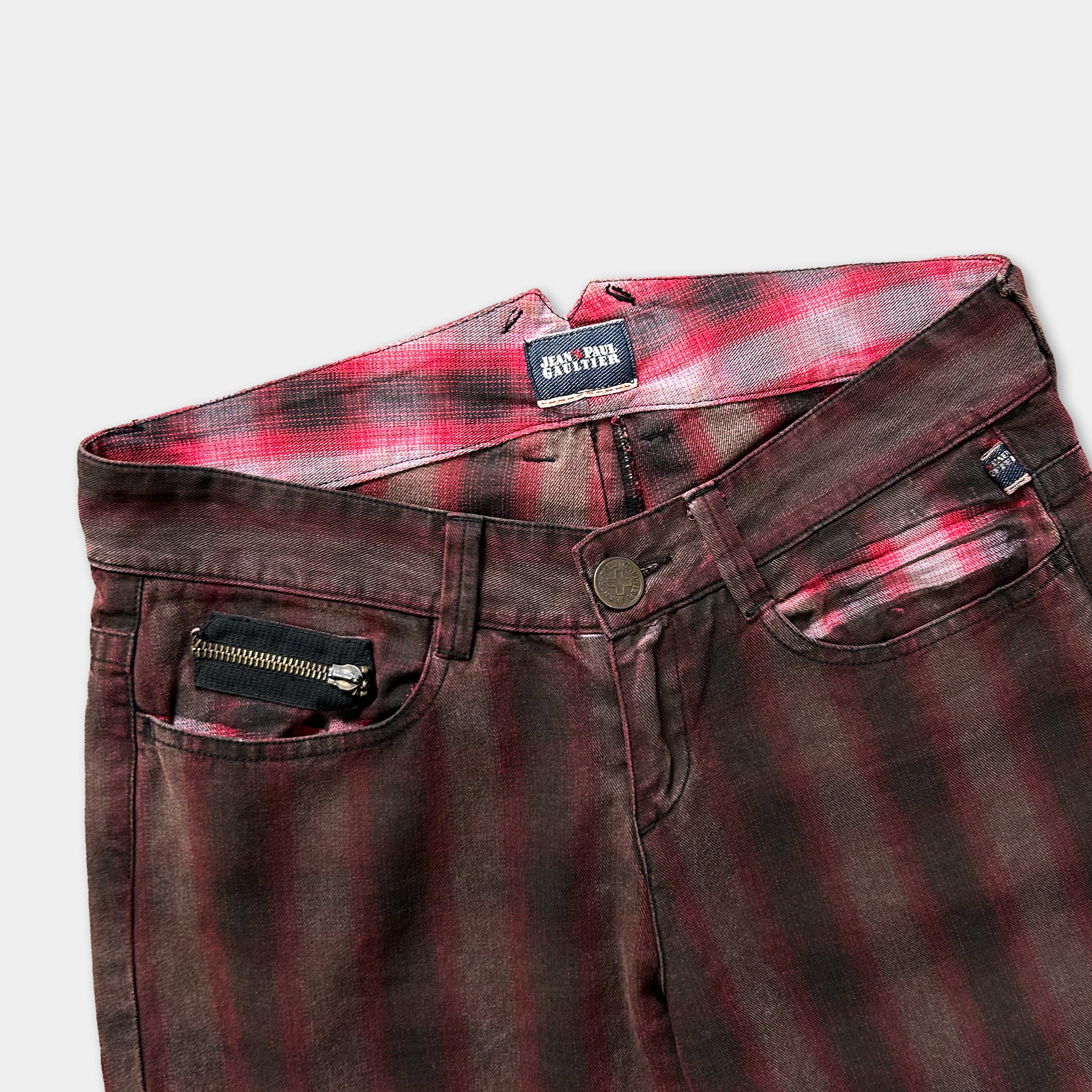 A pair of brown plaid jeans with a zipper pocket and a label on the waistband.